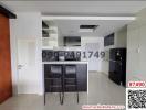 Modern kitchen with bar seating and tiled flooring in apartment