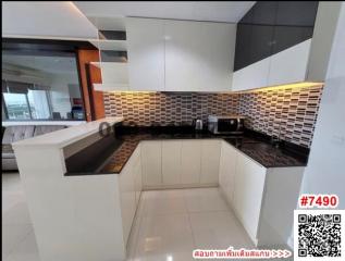 Modern kitchen with tiled backsplash and bar countertop