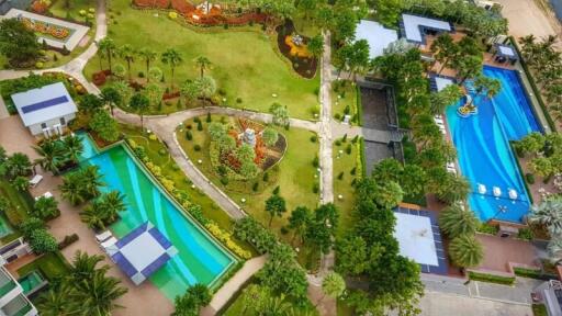 Aerial view of a luxurious residential complex with swimming pools and landscaped gardens