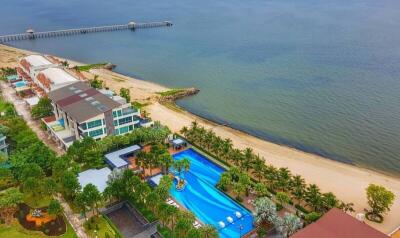 Aerial view of beachfront residential area with swimming pool and garden