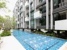 Modern apartment complex with outdoor swimming pool and garden