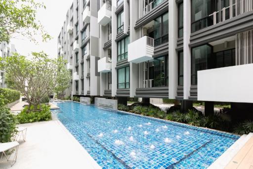 Modern apartment complex with outdoor swimming pool and garden