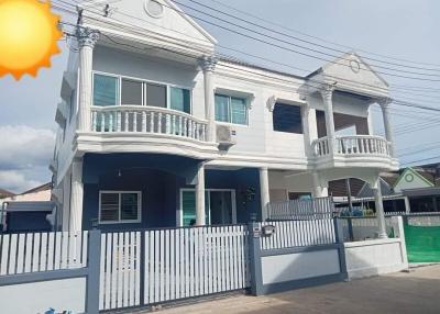 Bright two-story house with balconies and blue sky