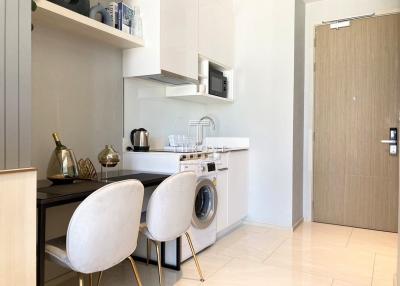 Modern kitchen with white walls featuring built-in appliances and small dining area