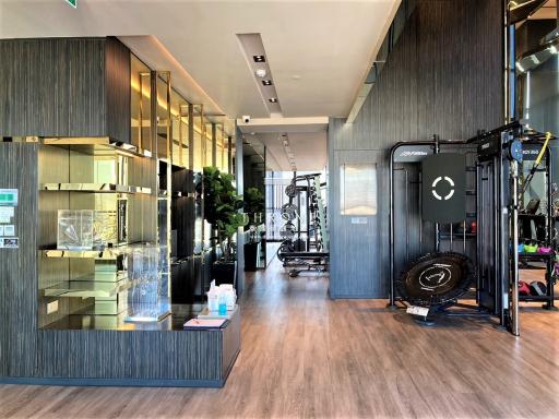 Modern gym facility inside an apartment building with fitness equipment and weights
