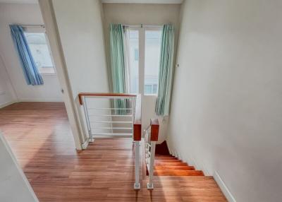Bright staircase area with wooden floors leading to a lower level