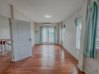 Spacious and well-lit living room with hardwood floors and balcony access