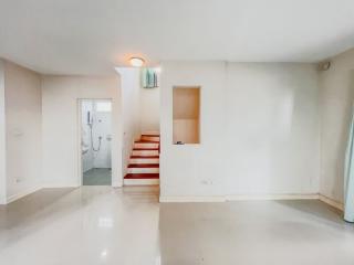 Spacious and bright living area with staircase and open doorway