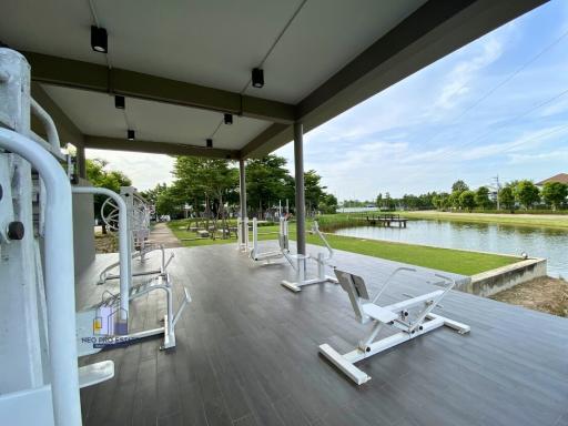 Outdoor gym equipment overlooking a serene pond in a residential area