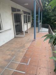 Spacious outdoor patio area with tile flooring and garden view