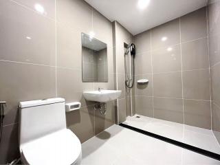 Modern bathroom with walk-in shower, wall-mounted toilet, and sink
