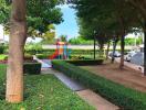 Lush green outdoor area with children's playground and walking path