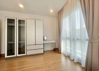 Spacious bedroom with modern wardrobe and wooden flooring