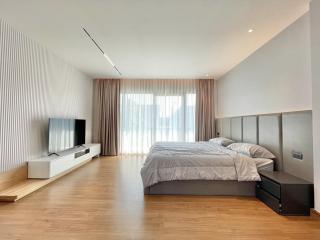 Spacious modern bedroom with hardwood floors and natural light