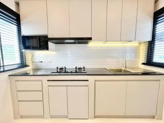 Modern kitchen with white cabinetry and stainless steel appliances