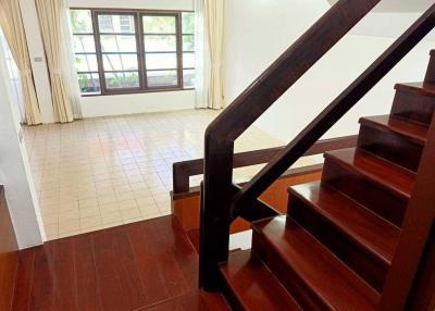 Staircase area leading to the upper floor in a house with wooden stairs and tiled flooring