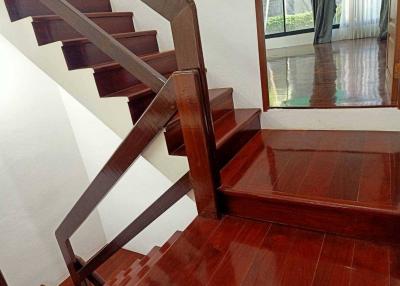 Polished wooden staircase with a view into a bright, spacious area