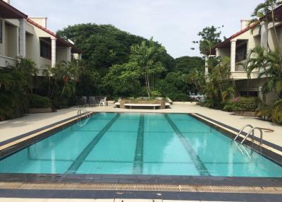 Outdoor swimming pool surrounded by residential buildings and lush greenery