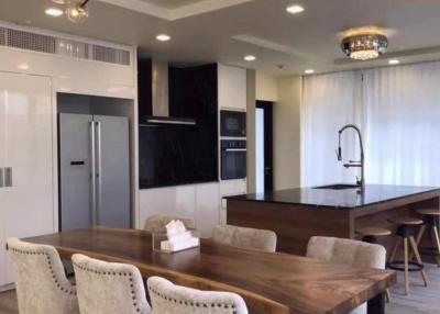 Modern kitchen with dining area featuring elegant lighting fixtures and state-of-the-art appliances