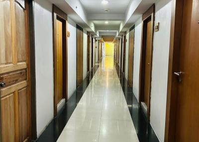 Long corridor with polished floors and multiple wooden doors
