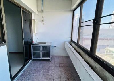 Enclosed balcony space with tile flooring and utility sink