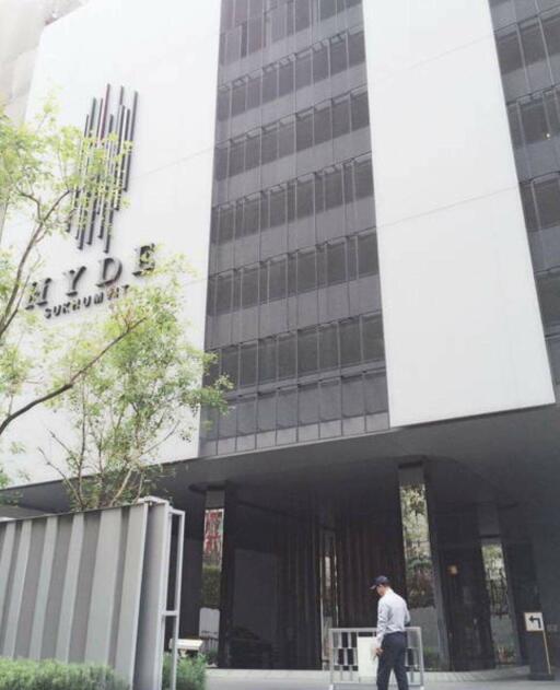 Modern residential building entrance with a person walking in front