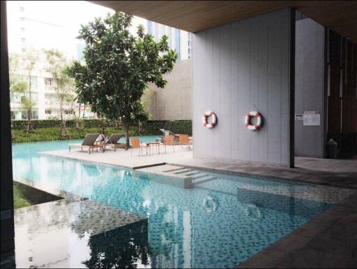 Modern apartment complex with a spacious outdoor swimming pool and lounging area