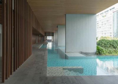 Modern building hallway with floor-to-ceiling windows overlooking a pool