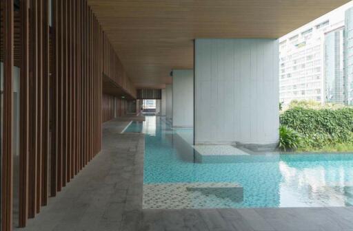 Modern building hallway with floor-to-ceiling windows overlooking a pool