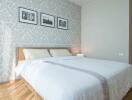 Modern bedroom with patterned wallpaper and framed photographs