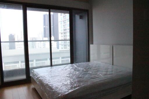 Spacious bedroom with large windows and city view