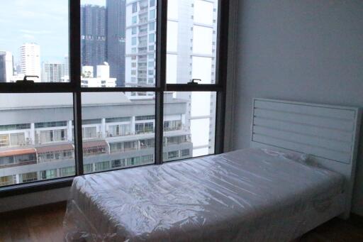 Bedroom with large windows and city view