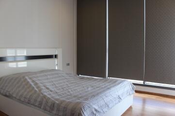 Modern bedroom with a neatly made bed and large wardrobe