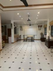 Spacious and well-lit living room with tiled flooring and ceiling spotlights