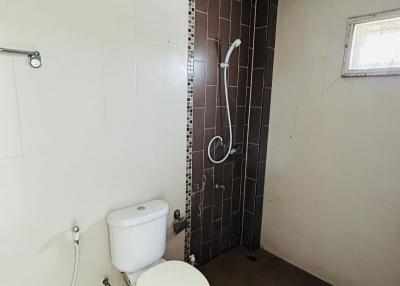 Compact bathroom with white fixtures and brown tiling