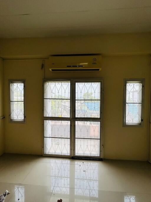 Bright living room with large windows and air conditioning unit