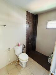 Compact bathroom with a shower area and ceramic tiling