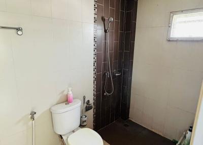 Compact bathroom with a shower area and ceramic tiling