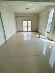 Spacious unfurnished living room with large windows and tiled flooring