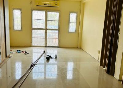 Spacious bedroom with tiled flooring, ample natural light, and air conditioning