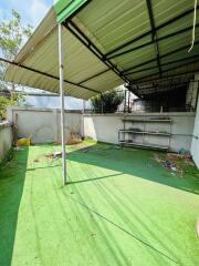 Backyard with artificial grass and awning