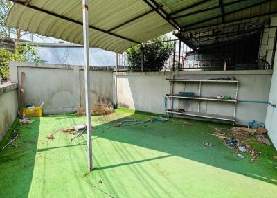 Backyard with artificial grass and awning