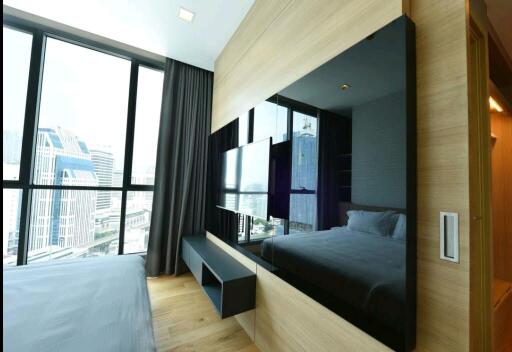 Modern bedroom with large windows and city view