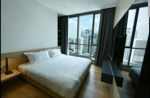 Modern bedroom with a beautiful city view through large windows