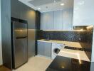 Modern kitchen with stainless steel appliances and black tile backsplash