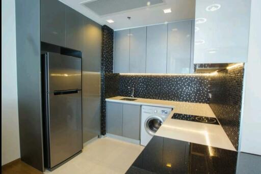 Modern kitchen with stainless steel appliances and black tile backsplash