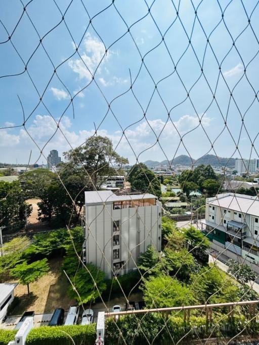 Urban view from behind a safety net showing buildings and green areas