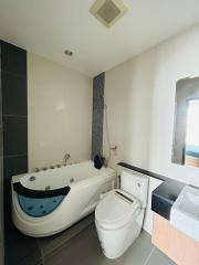 Modern bathroom with jetted tub, toilet, and sink