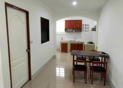 Modern kitchen with dining area, clean design, and tiled flooring