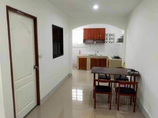 Modern kitchen with dining area, clean design, and tiled flooring